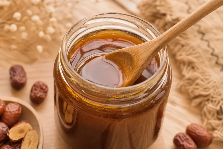 Pot de miel de jujubier bienfaits sur fond de bois clair